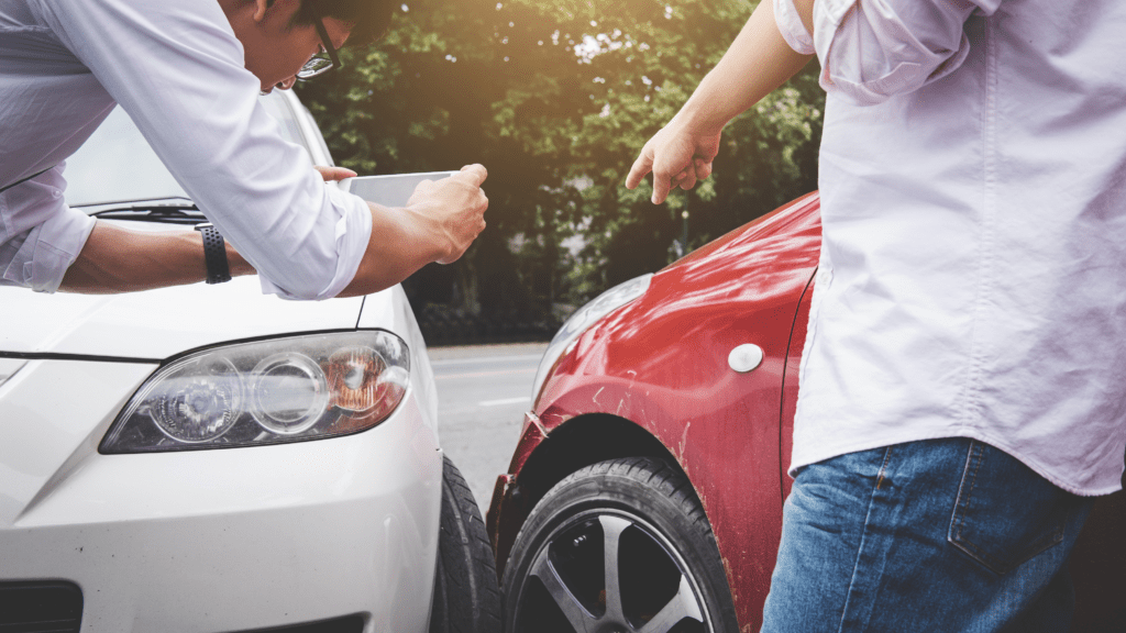 Driver photographing vehicle damage at a car accident scene in West Palm Beach Florida following steps advised by personal injury attorney The Dash Cam Lawyer